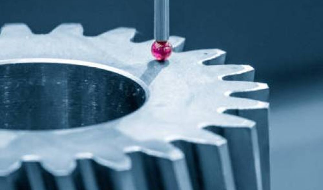 A Hexagon CMM probe touches a metal gear, measuring its dimensions with precision thanks to advanced CMM programming.