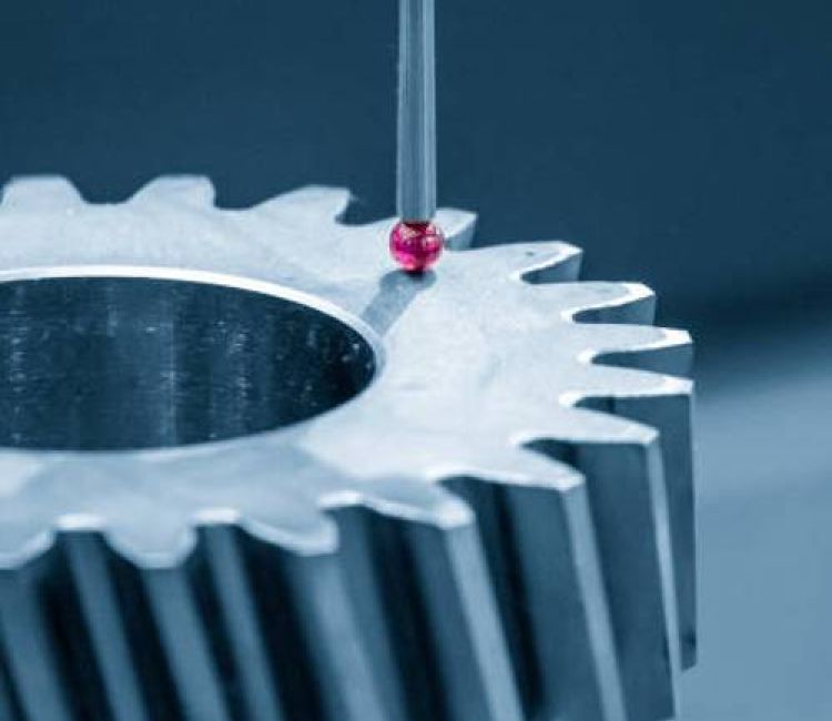A Hexagon CMM probe touches a metal gear, measuring its dimensions with precision thanks to advanced CMM programming.